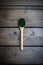 Green powder in spoon on old wooden table