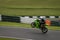 A green racing bike speeding round corners