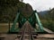 Green railway train tracks bridge over Urubamba river rainforest Hidroelectrica to Aguas Calientes Macchu Picchu Peru