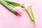 Green razor with beautiful pink tulip on a pink background. Hair removal concept.