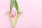 Green razor with beautiful pink tulip on a pink background. Hair removal concept.