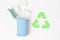 Green recycle garbage symbol, trash can and paper on white background, top view