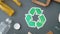 Green recycle symbol with household waste on grey