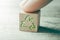 Green Recycling Icon On A Wooden Block On A Table, Touched By A Finger
