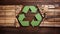 Green Recycling Symbol on wooden background, environment, ecology, Earth day concept