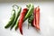 Green and red capsicum fruits on a white background