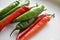 Green and red capsicum fruits on a white background