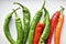 Green and red capsicum fruits on a white background