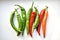 Green and red capsicum fruits on a white background