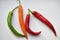 Green and red capsicum fruits on a white background