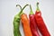 Green and red capsicum fruits on a white background