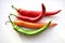 Green and red capsicum fruits on a white background