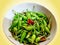 Green and Red Chilies in Bowl Isolated on Yellow