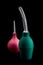 Green and red pear white tip for enema, isolate on a black background