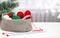 Green and red yarn in a knitted gray basket on a white table. Home comfort and christmas concept. Women`s and men`s hobby knitti