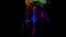 green, red and yellow glowing paints on woman, lady is dancing slowly in darkness