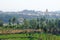 Green rice fields or terraces in the village of Hampi and the Temple of Virupaksha. Palm trees, sun, rice fields, large stones.