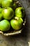 Green ripe organic bio apples, local produce, in rustic wicker basket on weathered wood table, harvest