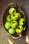 Green Ripe Organic Bio Apples Local produce in Rustic Wicker Basket Wood Table Harvest Autumn Fall Thanksgiving