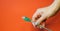 Green RJ45 network connector on a red background in well-groomed female hands