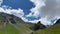 Green rocky slopes of the northern Elbrus region. Blue sky with white clouds.