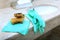 Green rubber or latex gloves and a cleaning sponge lie on the marble sink in the bathroom. The view from the top. Items of