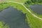 Green rural landscape on summer day. countryside with river and dirt road. aerial photo