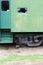 Green rusty side and door of an antique rail car with a broken out window