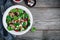 Green salad spinach bowl with quinoa, pomegranate, walnuts, feta cheese and dried cranberries.