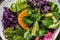 Green salad with sweet potatoes, broccoli, avocado, purple cabbage, cucumber, watermelon radish and almonds. Food recipe