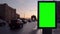 Green screen blank billboard on a busy street against sunset