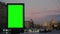 Green screen blank billboard on a busy street at sunset