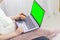 Green screen design concept. Side view of woman hands holding credit card using laptop at home, data security