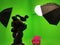 A green screen studio with complete equipment, video camera, lighting, umbrellas, bulb lighting. With a red chair