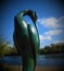 Green sculpture of relaxing bird.