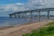 Green sea bay near the coast of the city, industry, big rounded Controlled-access highway bridge against a background of blue sky