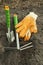 Green shovel and rake, garden gloves for seedlings