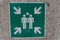 green sign pointing gathering place concrete wall