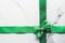 Green silk ribbon and bow on marble background, St Patricks day present or Christmas glamour gift decor for luxury digital brand,