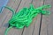 Green skein rope heap closeup on vintage wooden surface deck board, pier environment diversity,