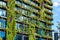 Green skyscraper building with plants on the facade