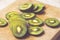 Green slices of kiwi fruit on wood cutting board