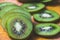 Green slices of kiwi fruit on wood cutting board