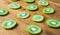 Green slices of kiwi fruit on wood cutting board