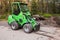 Green small forklift stands on a logging area