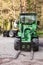 Green small forklift stands on a logging area