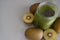 Green smoothie with chia in mason jar on gray background with kiwis.Detox cocktail, healthy diet concept with spinach, pineapple,