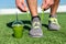 Green smoothie fitness man tying running shoes