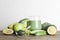 green smoothie in glass, spirulina powder, vegetables and fruits on wooden background.