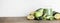 green smoothie in glass, spirulina powder, vegetables and fruits on wooden background.